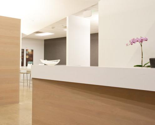 Renovated reception area with light wood veneer reception desk and wall feature